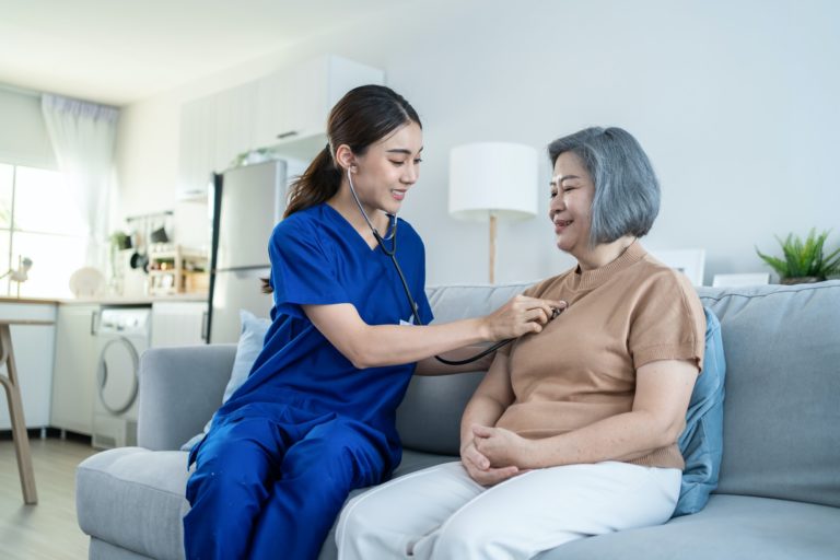 Asian nurse at nursing home take care of disabled senior elderly woman. Medical insurance service